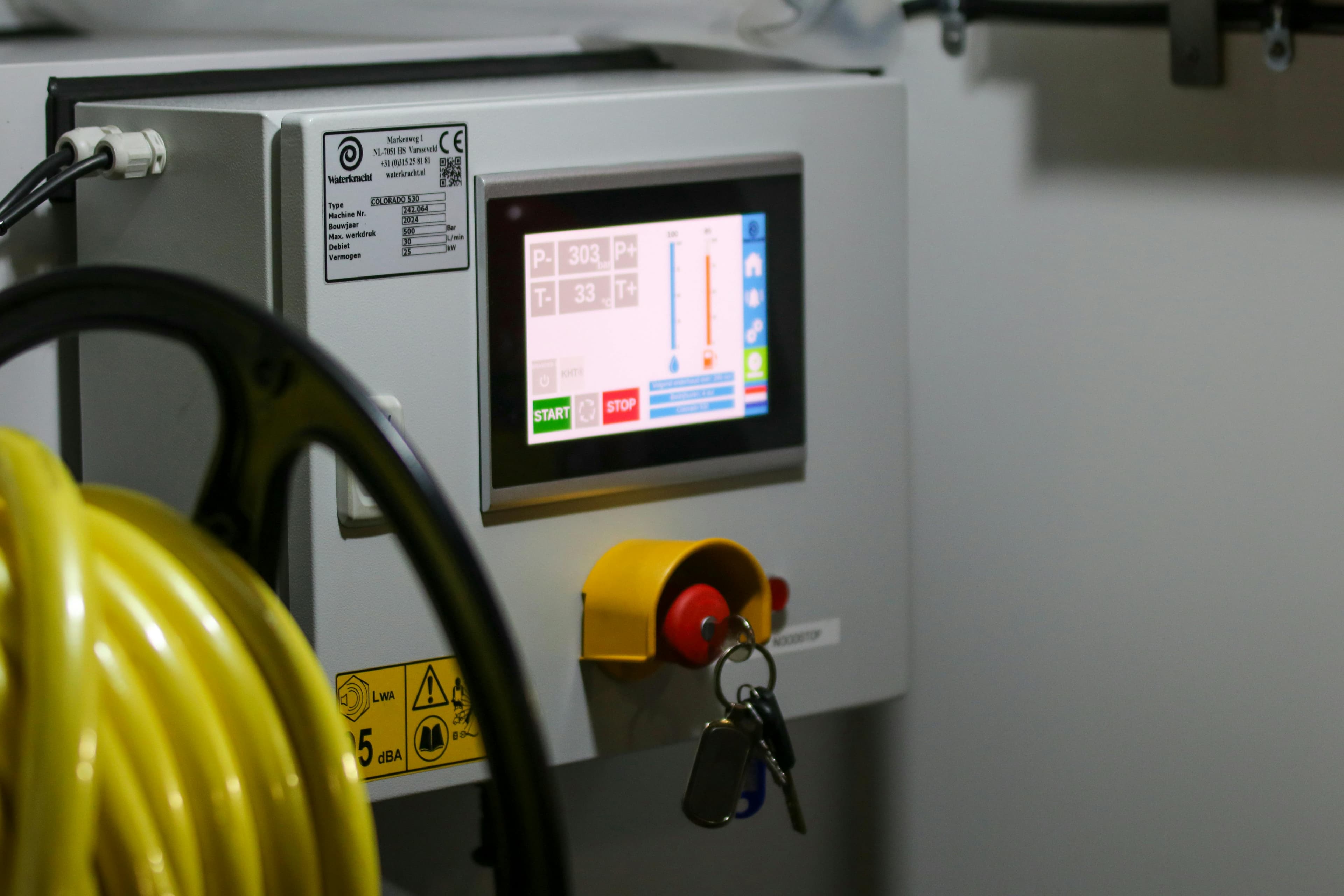 Industrial HMI touchscreen showing process values with emergency stop button