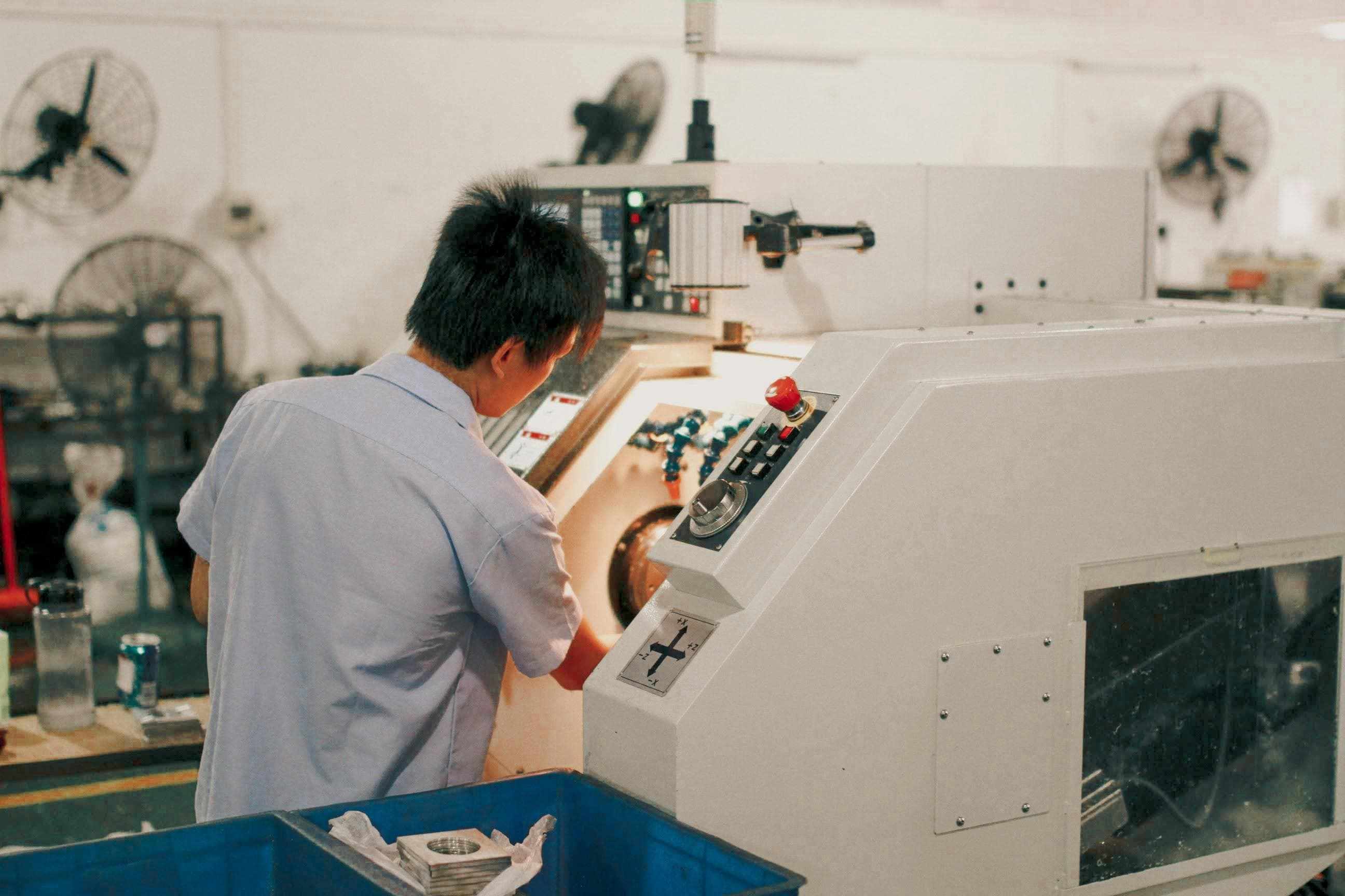 Operator working at industrial machine control panel